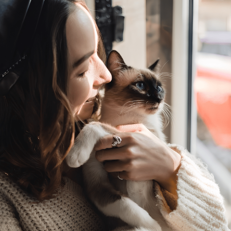 A woman cradles a cat in her arms